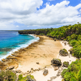 A tropical beach with sand and blue sea, highlighting our gloabl reach.