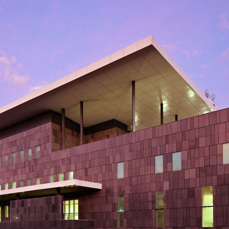 Exterior shot of a modern looking overseas embassy at dusk.