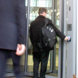 man with rucksack using pass to access a secure door